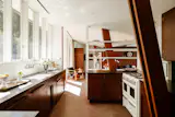 The kitchen features black phenolic resin countertops and handmade ceramic tile.