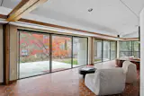 Sliding glass doors open the living area to a large patio and acres of forest.