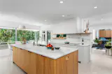 The kitchen is home to custom cabinetrey and provides dual balcony access.
