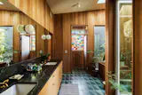 The primary bath features a wooden soaking tub and plenty of windows, including one made from stained glass.