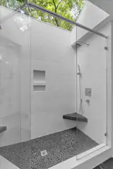 A skylight sits above and brightens the shower.