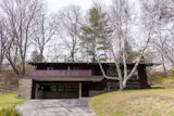 Inspired by Usonian homes, this 1957 residence by Herbert Fritz Jr. has wooden built-ins, concrete blocks, and purple carpet.