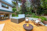 Alaskan yellow cedar decking, Marquis hot tub, and fire pit guild the lily in this stunning yard