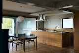 Third-floor living room featuring a wood stove, dining area, and kitchen