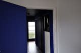 The glass door is our entrance & so our home welcomes you with full immersion blue. State housing builds like this typically have poky hallways. The darker tone emphasises this sense of contraction leading you towards the light filled space beyond & making it feel comparatively expansive.
