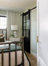 The guest bedroom feels like a stay at a rustic cottage. Wallpaper on all the walls in a lovely organic olive grove paper with a vintage brass bedframe is quaint and a perfect retreat.