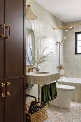 The guest bath also acts as a powder room. The walls are clad in a lovely handmade tile and the custom concrete sink is a gorgeous feature in the space. 
