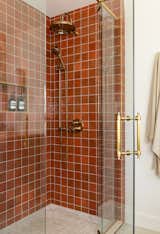 The principal retreat bathroom packs a punch and feels Mediterranean. Terracotta colored tiles, bold stone details and brass elements are a perfect mix.