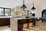 The granite counters waterfalls on one end to make the island a focal point. Sculptural pendants are a statement. 