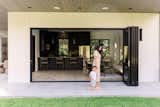 Mother and son walking and holding hands in front of bi-fold door. 