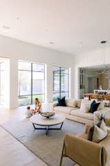 Girl and boy playing inside spacious home in front of RAM picture windows. 