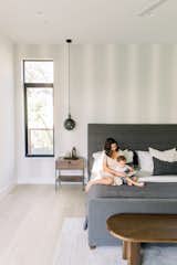 Mother and son read book on bed inside luxury home next to RAM casement window.