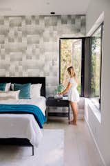 Girl places plant on bedside table with RAM casement window open beside her. 