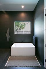 RAM aluminum picture window opens this modern bathroom space to beautiful outdoor views.