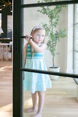 A girl opens a RAM swing door with modern grids in this Dallas area home.