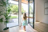 A girl opens a RAM swing door with modern grids.