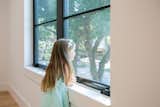 A girl looks out this RAM double casement window with a screen.