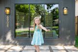 A girl plays in front of the RAM picture window with grids.