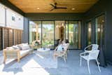 A family enjoys lounging on the back porch next to the large RAM sliding door which creates a seamless transition between indoors and outdoors.
