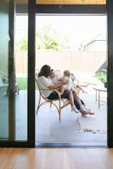 A family enjoys lounging on the back porch next to the large RAM sliding door which creates a seamless transition between indoors and outdoors.