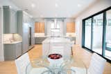RAM aluminum sliding doors illuminate the open-concept living and kitchen areas.
