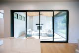 RAM aluminum sliding doors illuminate the open-concept living and kitchen areas.