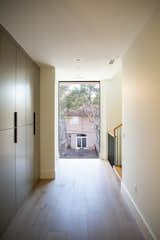 Large RAM picture window creates a focal point at the end of this modern hallway.