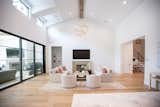 RAM picture windows at the ceiling help to draw the eye upward to natural beams and a grand chandelier in this living space.