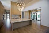 The modern open-concept kitchen in Westlake, TX is illuminated with natural light from RAM sliding doors.
