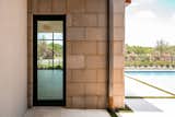 RAM swing door creates an open transition between this outdoor guest house and the pool area.