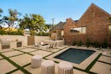 Outdoor pool area with multiple seating areas and built in outdoor kitchen. 