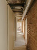Space Redistribution

The interior design begins with a hallway that restores the original textures of the structural brick in the central load-bearing wall. This hallway distributes the various rooms through existing and new openings. The load-bearing wall divides the service area, which includes the kitchen and bathroom, from the living area and bedrooms.