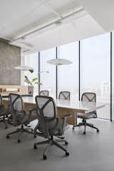 Conference room : 

Behind the discussion area is the library and conference area. Designed around the huge column in the space, the room is divided into three parts with the main conference table in the centre, the library tucked behind the column and a comfortable, unwinding space across the table for the team to delve deep into thought. An interesting detail to note in this space is the cantilevered conference table, almost 15 ft in length projecting out into space.