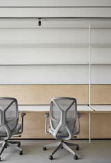 Workstations :

Besides the birch plywood furniture, another anchor point for the design was the thin, easily overlooked metal strip lighting above the workstations. This lighting provided ambient illumination, casting a soft glow that mimicked the natural daylight washing over the ceiling.