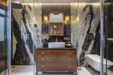 Crafted from exquisite Black Panda marble, the walls exude sophistication, with fluid white patterns cascading gracefully from floor to ceiling. The vertically laid marble slabs in the shower and WC cubicles create a mesmerizing visual effect, accentuating the grandeur of the space.