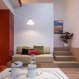A custom-made seating set on a raised platform doubles as a stair landing, making it an inviting spot for gatherings.