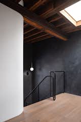 View looking northeast on the upper floor. The entire east wall of the house is clad in a textured charcoal polished plaster to accentuate the existing wood structure. 