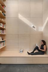 A custom carpentry piece with a bench and a bookshelf extends to the sloped upper windows at the front of the structure