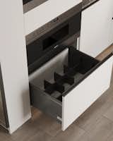 A pantry with built-in appliances embodies the essence of minimalist modern design. Its sophistication is further elevated by added features like a pull-out spice rack, enhancing functionality and maximizing storage space.