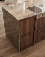 The sophisticated Dekton Arga surface blends beautifully with the warm wood tones of the cabinets, enhancing the kitchen's natural and sophisticated aesthetic.