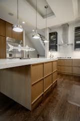 The kitchen island highlights the clean-lined framing typical of Japandi design, finished in a warm golden oak. A durable quartz countertop completes the look, adding contrast and refinement.