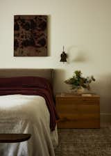 Our main bedroom wanted to be calm and textural for our clients. We custom-made a King-size bed with a lower, more minimal headboard to let the ceiling draw the attention. To patinated vintage sconces and a Petite wooden French bench with radius ends that has the most beautiful, rich, and subtle patina, our custom New Vintage Ghent Side Tables from ROWEAM in natural stain and layered with my favorite Swedish vessels of all time, anything Gunnar Nylun. The little desk nook wanted to be airy and simple with a metal and leather-topped desk and our Javor Pivka chair.