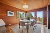 The redwood paneled dining room has new Marvin Windows and a door to a new dual level deck
