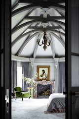  A fragment of a bedroom. The fireplace, table and clock are all French antiques from the 18th century. The painting on the wall is “Girl with Grapes” by Alexei Kharlamov (1890–1900).

Elena and Ilya thought for a long time whether to “sew up” the high vaulted ceilings or leave them as is. In the end, they settled on the 
second option, of course, adapting the rough finish to the style developed for the interior.