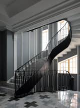 View of the staircase from the hallway. The metal staircase designed by "Art Bureau 1/1| Oneoverone" was manufactured by the company “Caspell”.

The architects of "Art Bureau 1/1| Oneoverone" are generally very sensitive to finishing with an interesting texture and pattern. They painstakingly selected the shades of pink and black-green marble they needed to lay out the “Byzantine crosses” pattern in the hallway. 