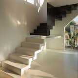 The texture of the floor and wall transforms into a staircase, while the metal of the mezzanine appears to float, also becoming stairs