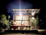 Estudio Sereno at Cabaña Serena embodies sustainable design and tranquil living. Its thoughtful architecture integrates seamlessly with the surrounding nature, featuring an intricate canopy that provides both shade and artistic detail. The warm lighting enhances the cozy ambiance, while the lush landscaping and bamboo accents reflect a commitment to eco-conscious living. A serene retreat for those seeking harmony with nature.