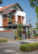 The exterior of the house blending modern minimalism with traditional elements, featuring exposed brick, and Mangalore-tiled roofs.