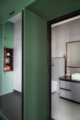 A minimalist monochromatic washroom and walk-in closet, elegantly accented with wooden highlights and subtle grooves.