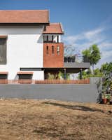 The side elevation reveals the cascading layers of the sloping roof, where terracotta tiles meet crisp white walls.